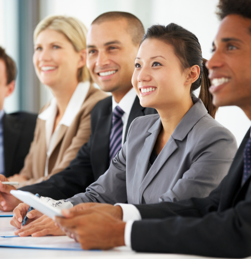 Smiling professionals listening together at a conference table
