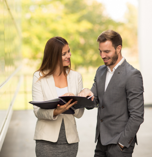 Two colleagues reviewing a folder together while planning